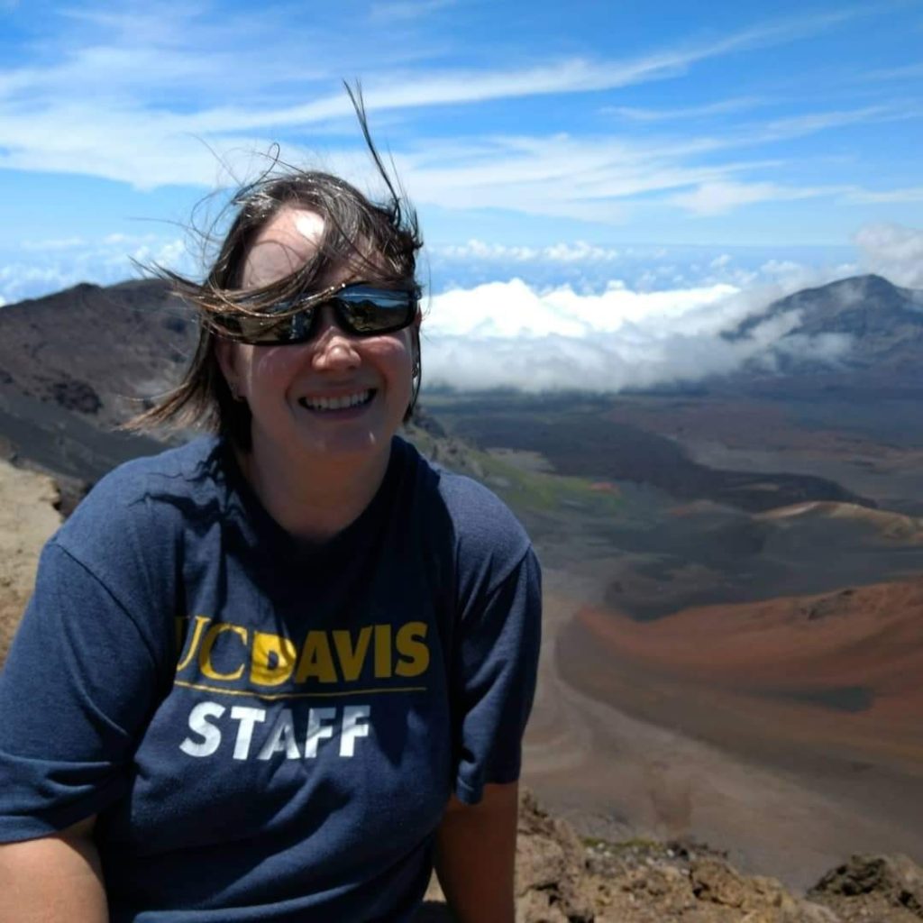 Carrie Cohen sitting in scenic mountain view in a UC Davis Staff shirt